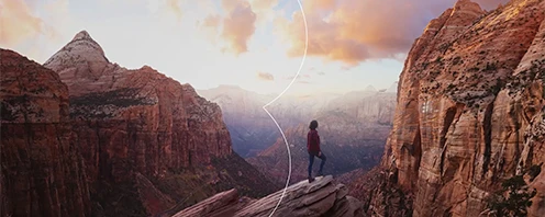 Person overlooking mountains representing JTB global business solutions and cross-border connections