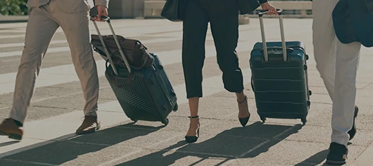 Business travelers with luggage walking to a corporate trip as part of JTB global business travel services