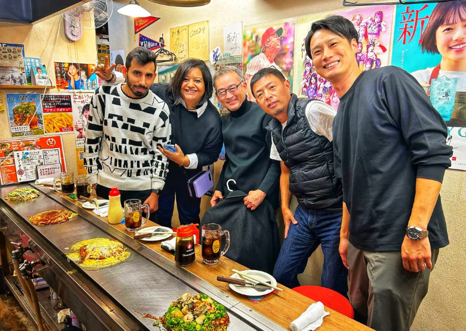 日本の飲食店で食事を楽しむ研修旅行の参加者と運営スタッフ